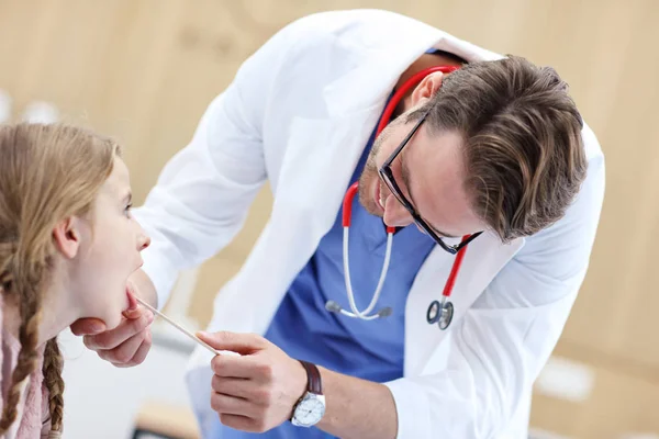 Klein meisje in kliniek met een checkup met laryngologist — Stockfoto