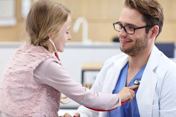 Klein meisje in kliniek met een checkup met kinderarts — Stockfoto