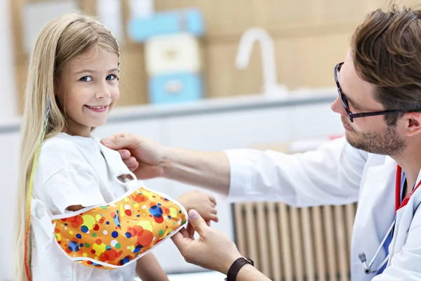 Male pediatrician checking bandage of little girls broken arm — Stock Photo, Image