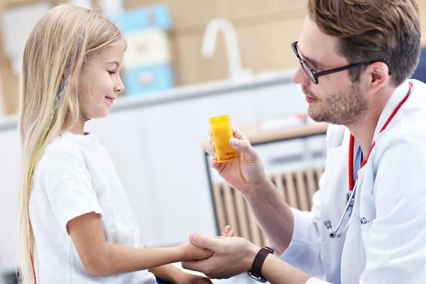 Male doctor giving pills to little girl — Stock Photo, Image