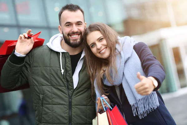 Alışveriş yaptıktan sonra alışveriş torbalarıyla mutlu bir çiftin portresi. — Stok fotoğraf