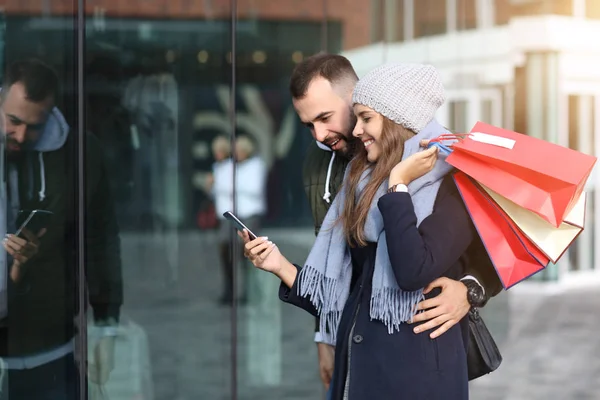 Portré a boldog pár bevásárló táskák vásárlás után a városban — Stock Fotó
