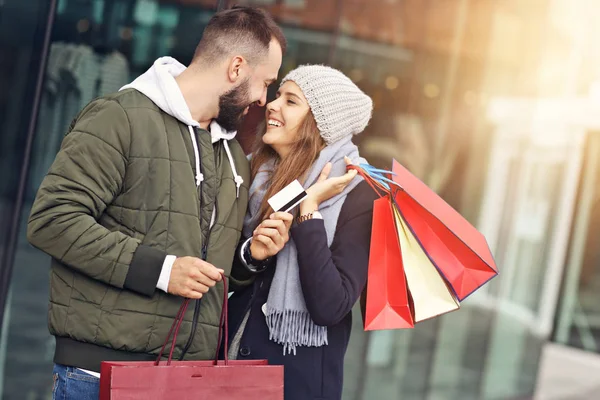 Retrato de pareja feliz con bolsas de compras después de comprar en la ciudad — Foto de Stock