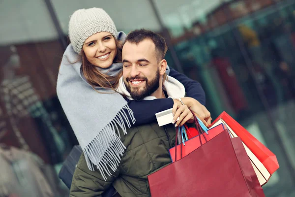 Retrato de casal feliz com sacos de compras depois de fazer compras na cidade — Fotografia de Stock