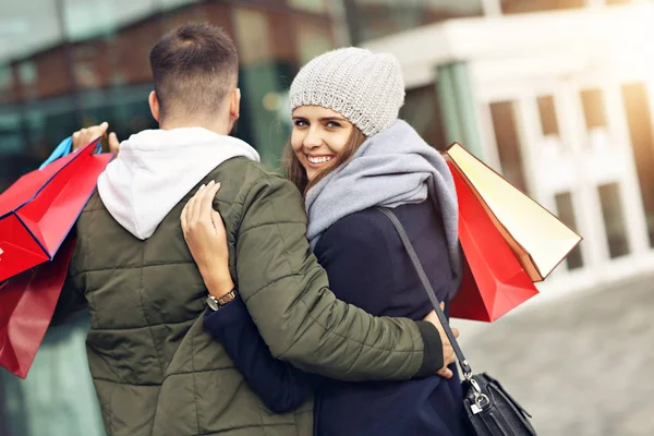 Retrato de pareja feliz con bolsas de compras después de comprar en la ciudad — Foto de Stock