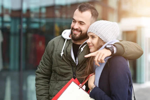 Retrato de casal feliz com sacos de compras depois de fazer compras na cidade — Fotografia de Stock