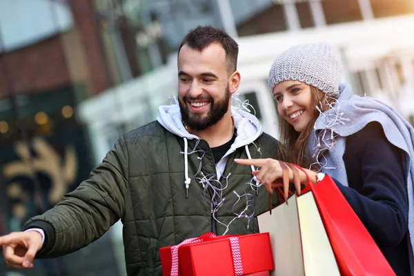 Retrato de casal feliz com sacos de compras depois de fazer compras na cidade — Fotografia de Stock