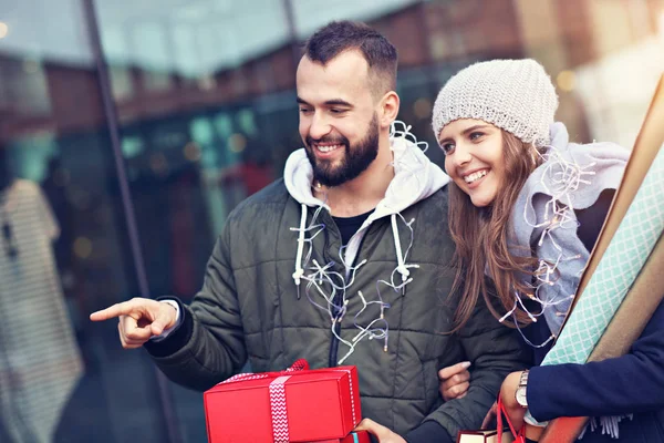 Retrato de casal feliz com sacos de compras depois de fazer compras na cidade — Fotografia de Stock