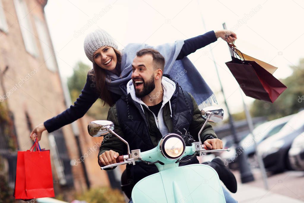 Portrait of happy couple with shopping bags after shopping in city