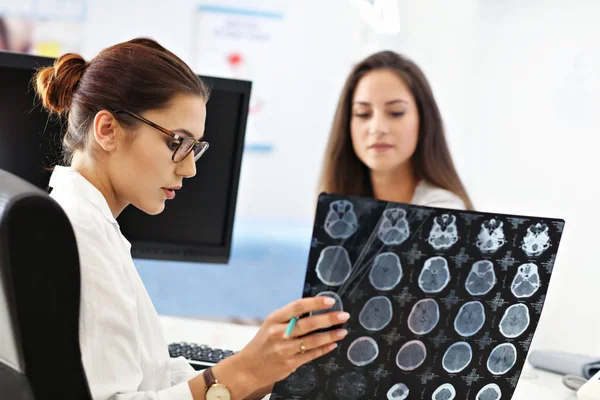 Vuxen kvinna diskutera röntgenresultat under besök på kvinnliga läkare kontor — Stockfoto