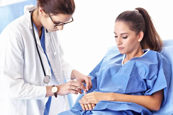 Female doctor taking care of patient in hospital — Stock Photo, Image