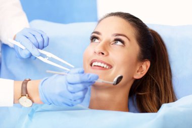 Picture of adult woman having a visit at the dentists clipart