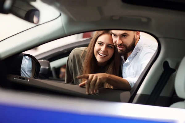Adult couple choosing new car in showroom — Stock Photo, Image