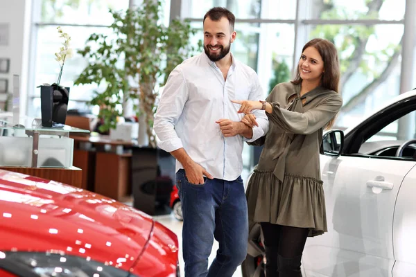 Adulto casal escolhendo carro novo no showroom — Fotografia de Stock