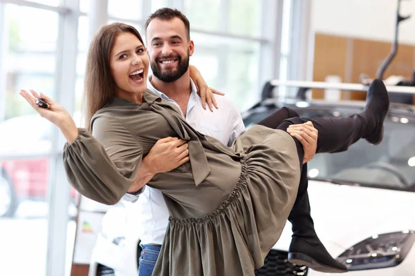 Pareja adulta eligiendo coche nuevo en sala de exposición — Foto de Stock