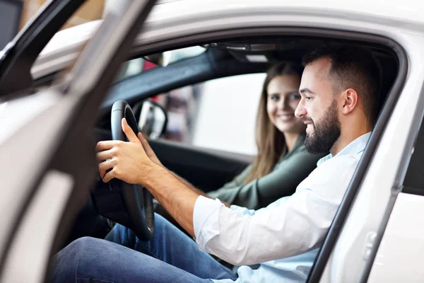 Adulto casal escolhendo carro novo no showroom — Fotografia de Stock