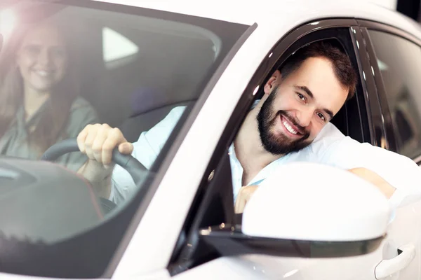 Pareja adulta eligiendo coche nuevo en sala de exposición —  Fotos de Stock