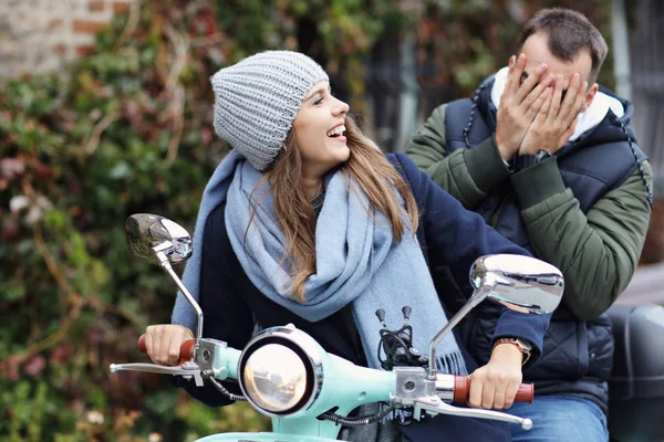 Hermosa pareja joven sonriendo mientras monta scooter en la ciudad en otoño — Foto de Stock