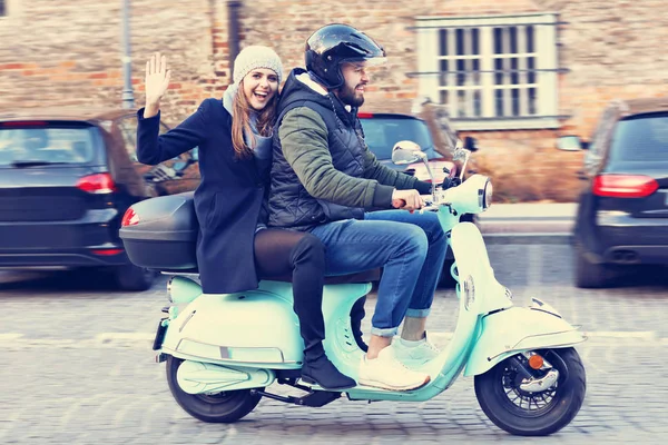 Mooie jonge paar glimlachen tijdens het rijden van scooter in stad in de herfst — Stockfoto
