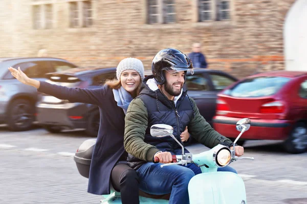 Mooie jonge paar glimlachen tijdens het rijden van scooter in stad in de herfst — Stockfoto