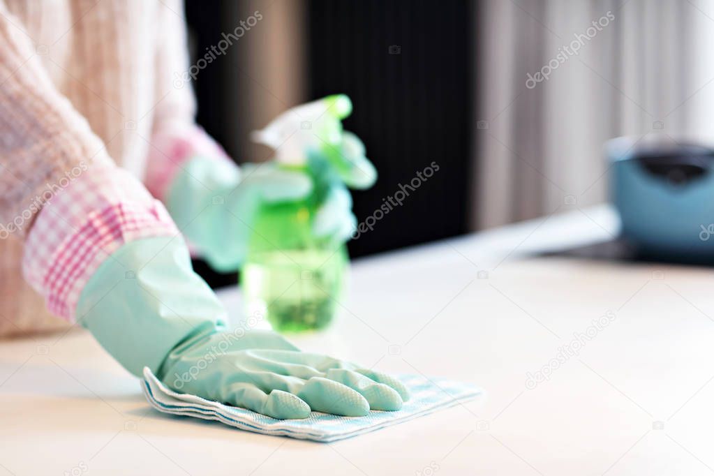 Happy woman cleaning kitchen countertop