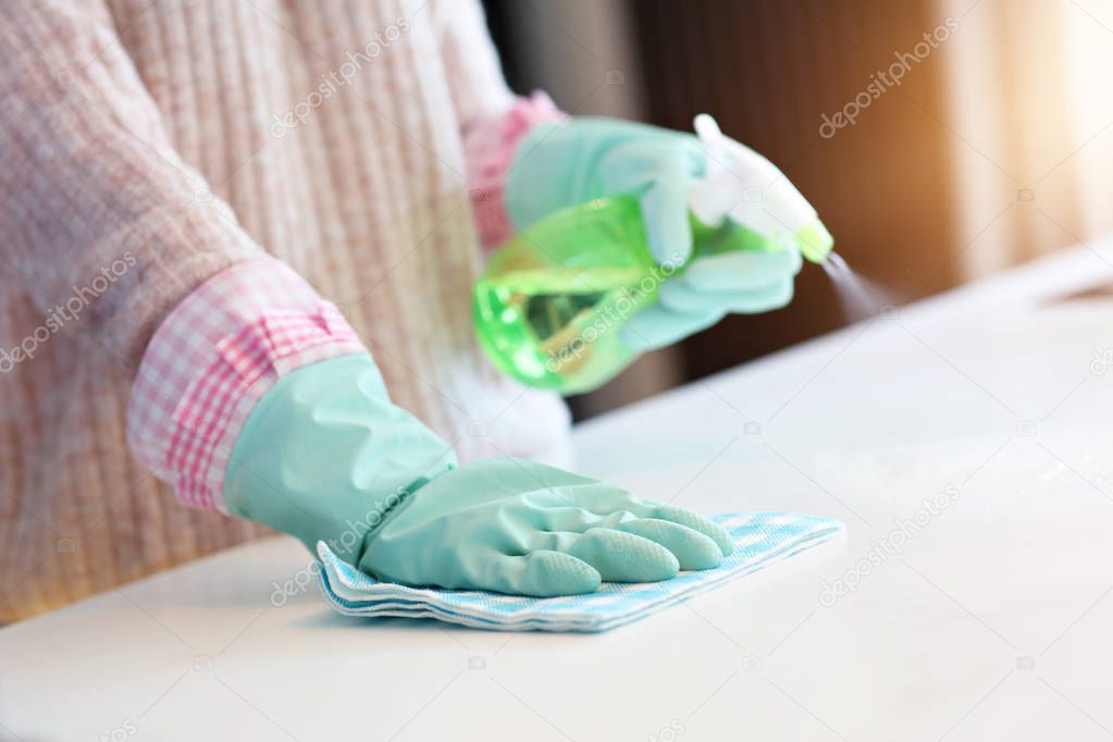Happy woman cleaning kitchen countertop