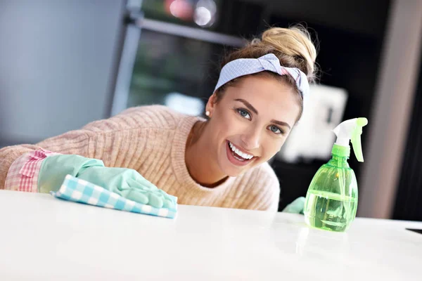 Mujer feliz limpieza encimera de cocina —  Fotos de Stock