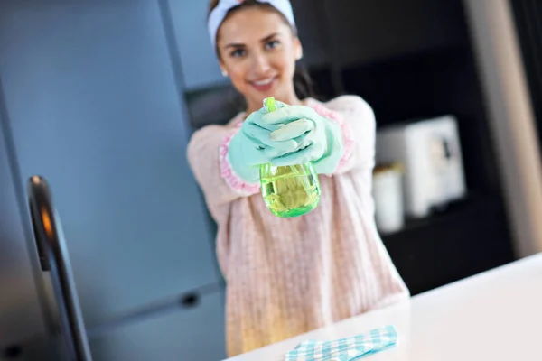 Счастливая женщина уборка кухни столешницы — стоковое фото
