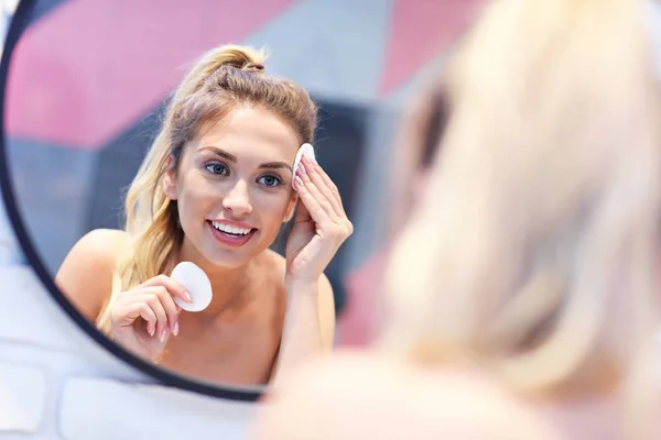 욕실 거울에 얼굴을 청소 하는 젊은 여자 — 스톡 사진