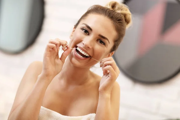 Ung kvinna borsta tänderna i badrummet — Stockfoto