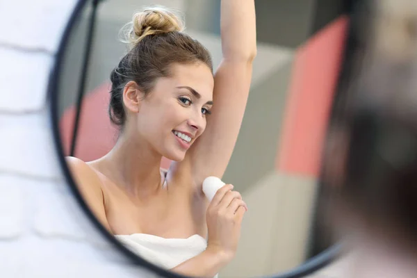 Fiatal nő segítségével dezodor, fürdőszoba — Stock Fotó