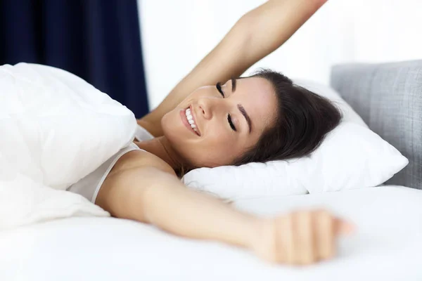 Mooie jongedame in haar bed volledig uitgerust wakker — Stockfoto