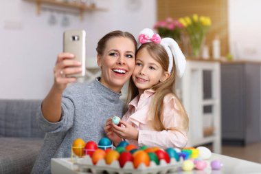 Anne ve kızı Paskalya yumurta boyama ve selfie alarak