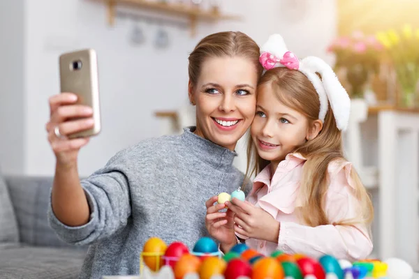Madre e hija pintando huevos de Pascua y tomando selfie —  Fotos de Stock
