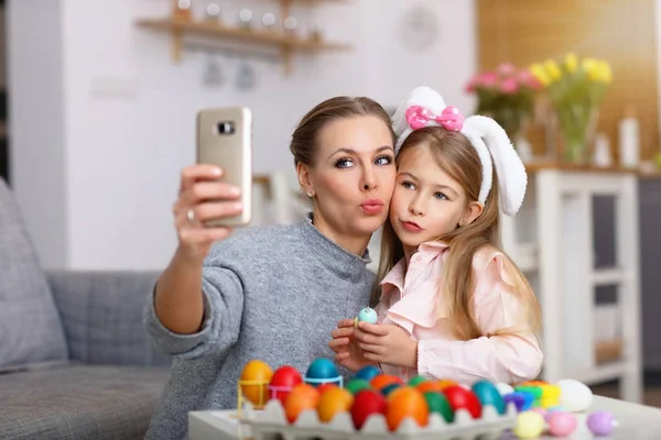 Madre e hija pintando huevos de Pascua y tomando selfie —  Fotos de Stock