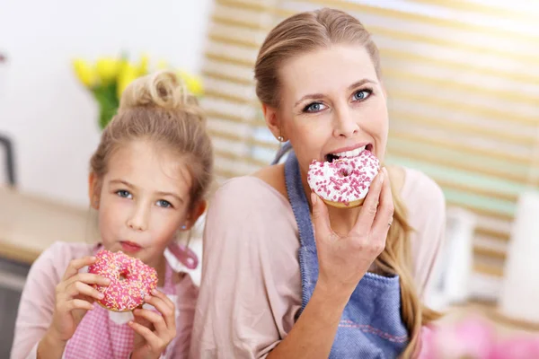 Klein meisje en haar moeder in schorten plezier in de keuken — Stockfoto