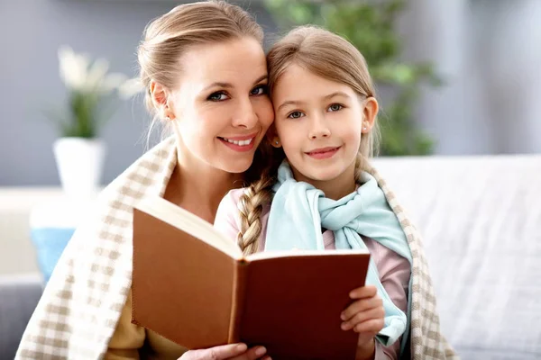 Bella mamma e sua figlia leggendo a casa — Foto Stock