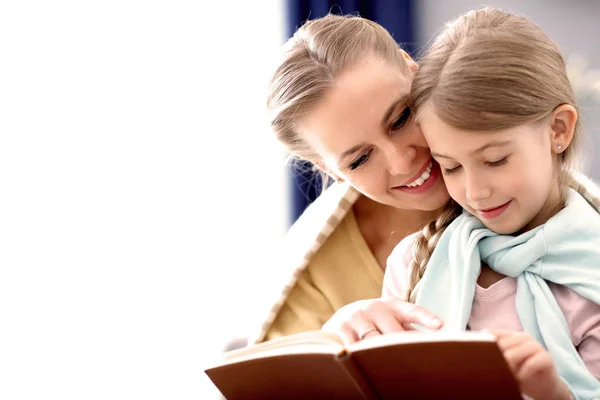 Krásná maminka a její dcera čtení doma — Stock fotografie