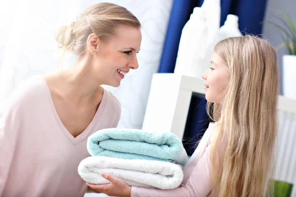 Gyönyörű fiatal nő és gyermek lány szórakozás rövid idő csinálás mosoda otthon — Stock Fotó