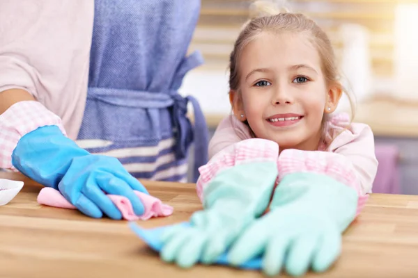 Bambina e sua madre in grembiuli pulizia della cucina — Foto Stock