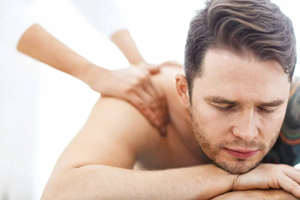 Knappe man met massage in de spa salon — Stockfoto