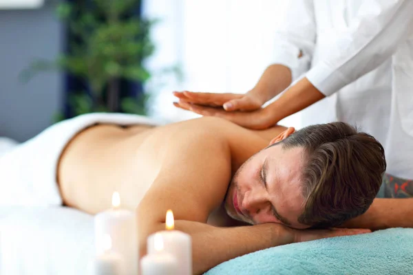 Hombre guapo teniendo masaje en el salón de spa — Foto de Stock