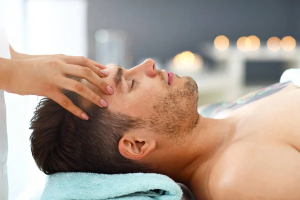 Pohledný muž s masáží v salonu spa — Stockfoto