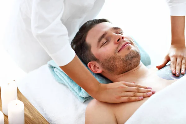 Schöner Mann mit Massage im Wellness-Salon — Stockfoto