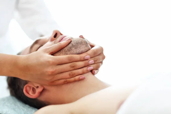 Bonito homem fazendo massagem no salão de spa — Fotografia de Stock