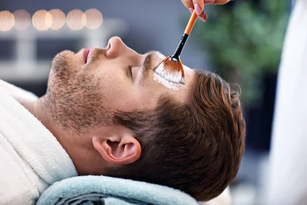 Hombre guapo teniendo facial en el salón de spa —  Fotos de Stock