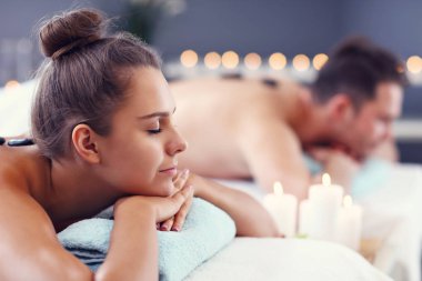 Adult happy couple relaxing in spa salon clipart