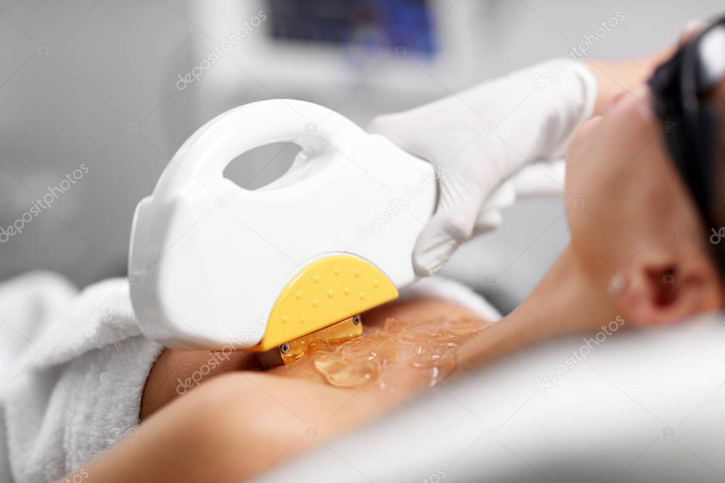 Beautician Giving Epilation Laser Treatment To Woman On Cleavage