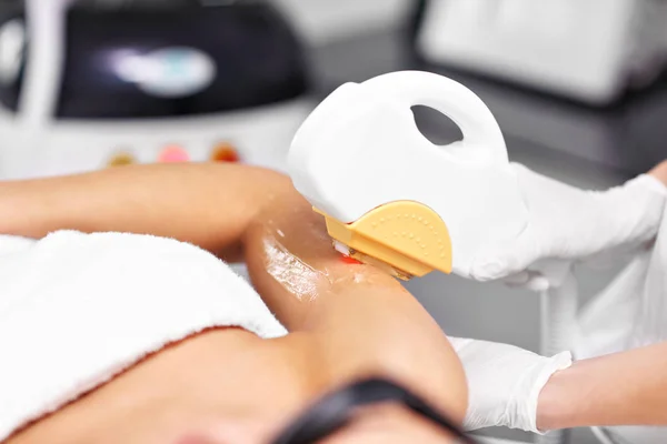 Kosmetolog ge epilation laser behandling till kvinna på armar — Stockfoto