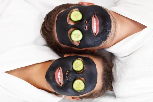 Glückliches Paar mit Gesichtsbehandlung im Wellness-Salon — Stockfoto